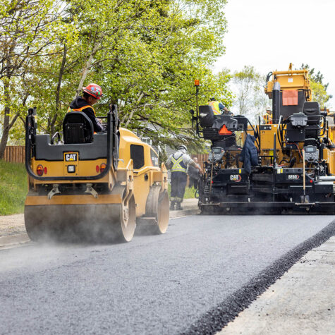 A group of United Concrete & Asphalt workers paving asphalt roads.